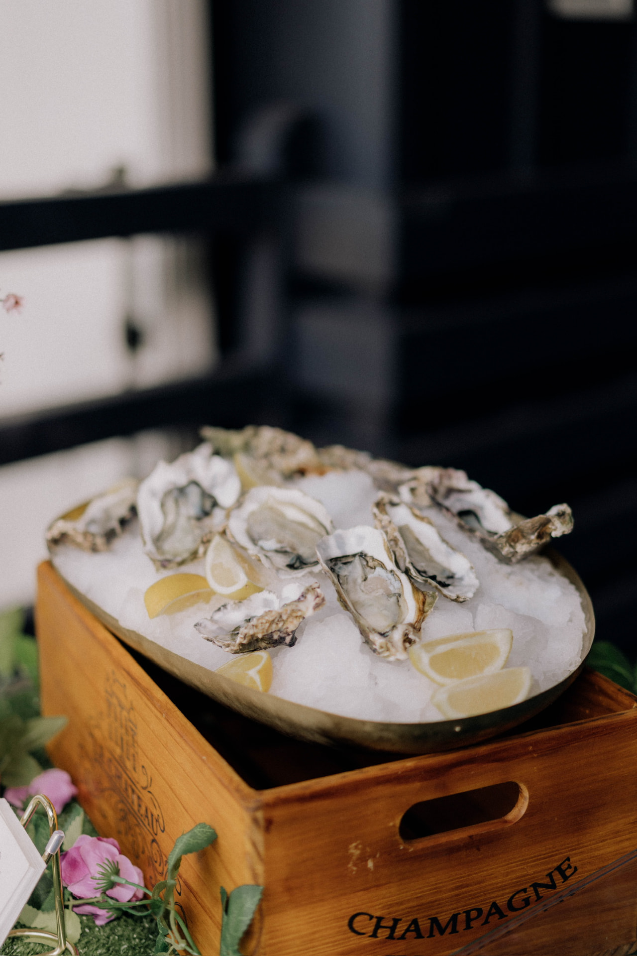 Vintage wooden champagne crate display with a brass platter of shucked oysters
