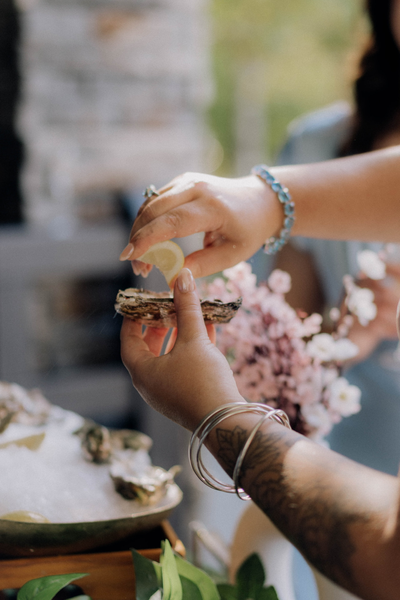 Guest squeezing lemon over a freshly shucked oyster at an Auckland event