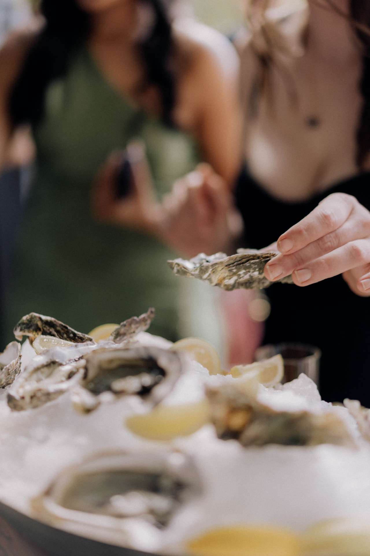Wedding guest taking a freshly shucked oyster from the platter